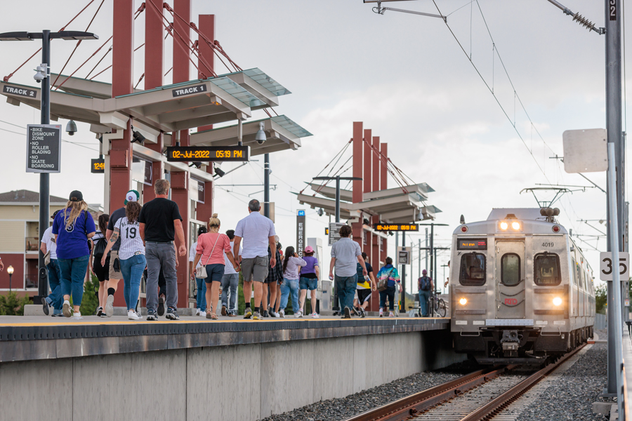 A N-Line train is arriving at a busy station in the Denver area.