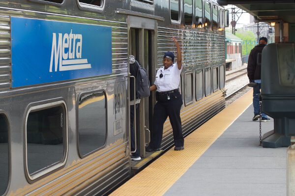 A conductor is waiving to the engineer that the train is ready to move.