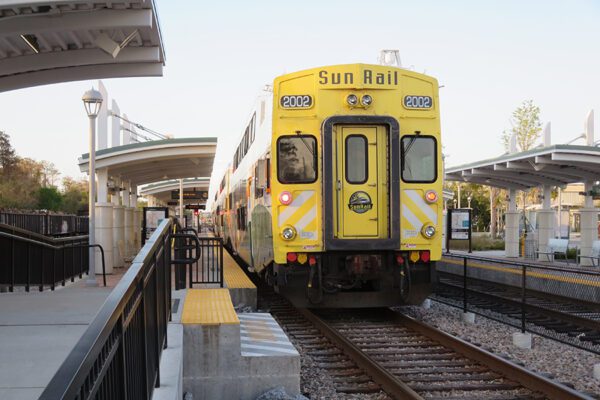 A Sunrail train is in a station.
