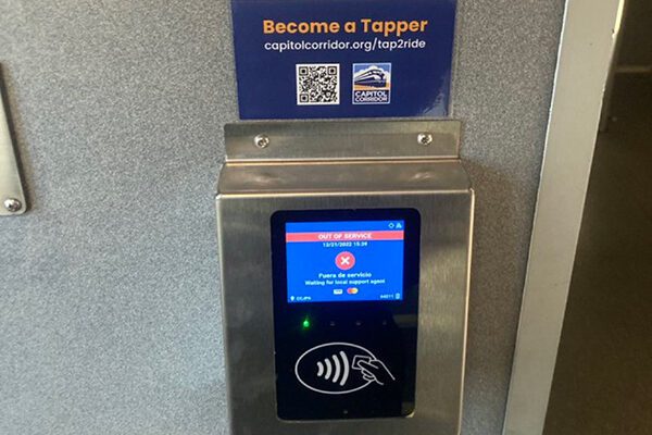 A credit card reader mounted on the wall in the entrance of a Capitol Corridor train in California.
