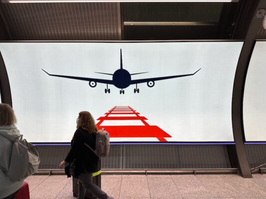 A poster with an artistic silhouette of a plane landing on railroad tracks to symbolize coordiated air/rail service at Frankfurt.