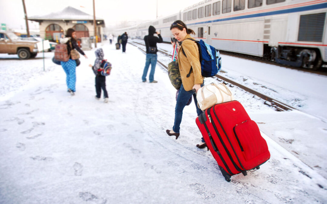 Woman pulling luggage through snow after deboarding an Amtrak train in Oregon