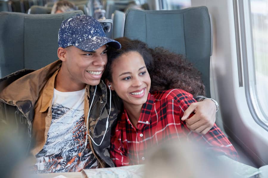 couple sharing headphones on a train