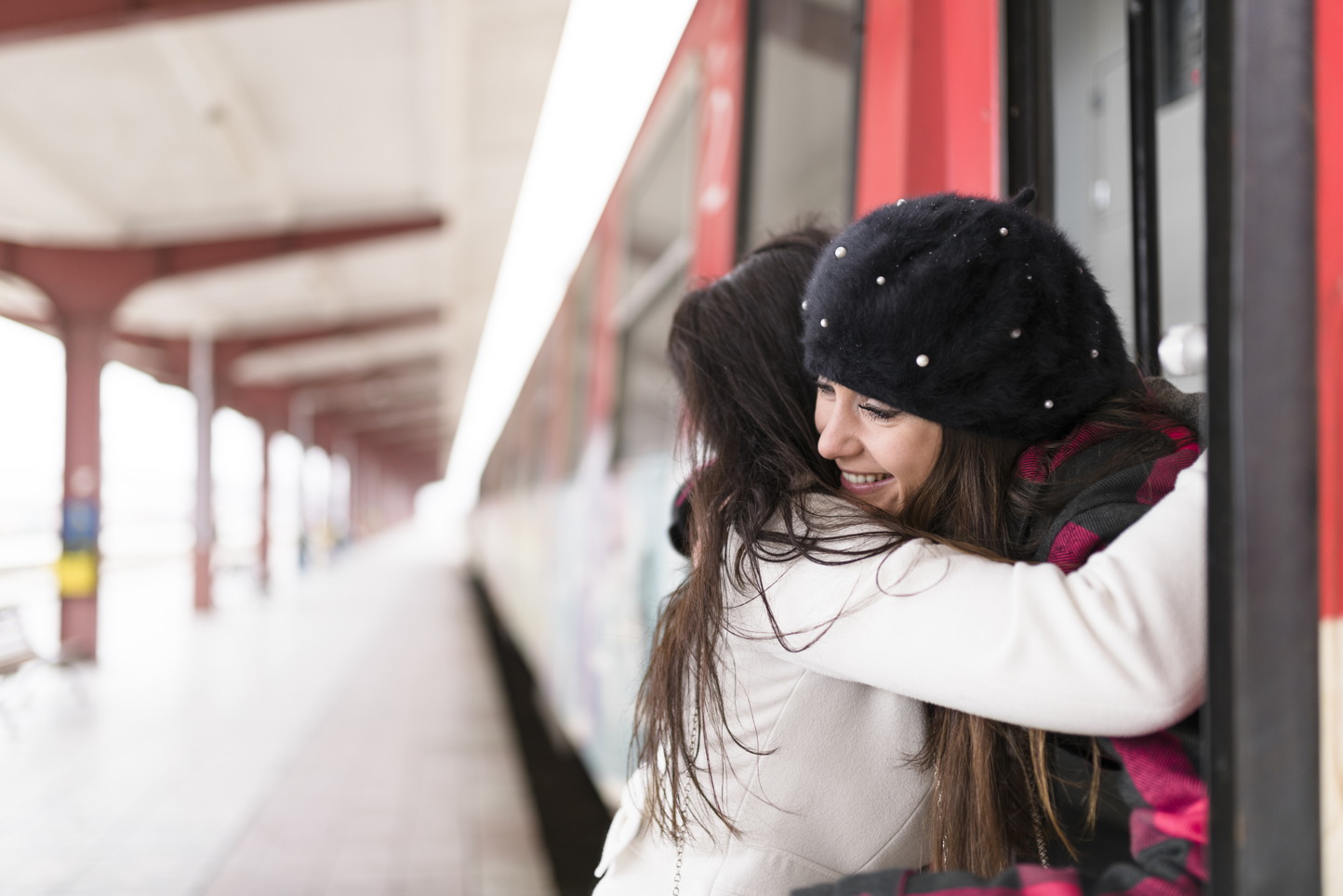 Attractive tourist receiving a goodbye hug. Located at the BDZ train station in Varna, Bulgaria.