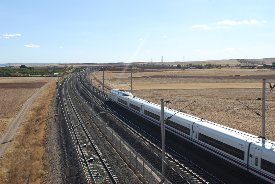 An AVE train heading south from Ciudad Real, Spain on a sunny afternoon.