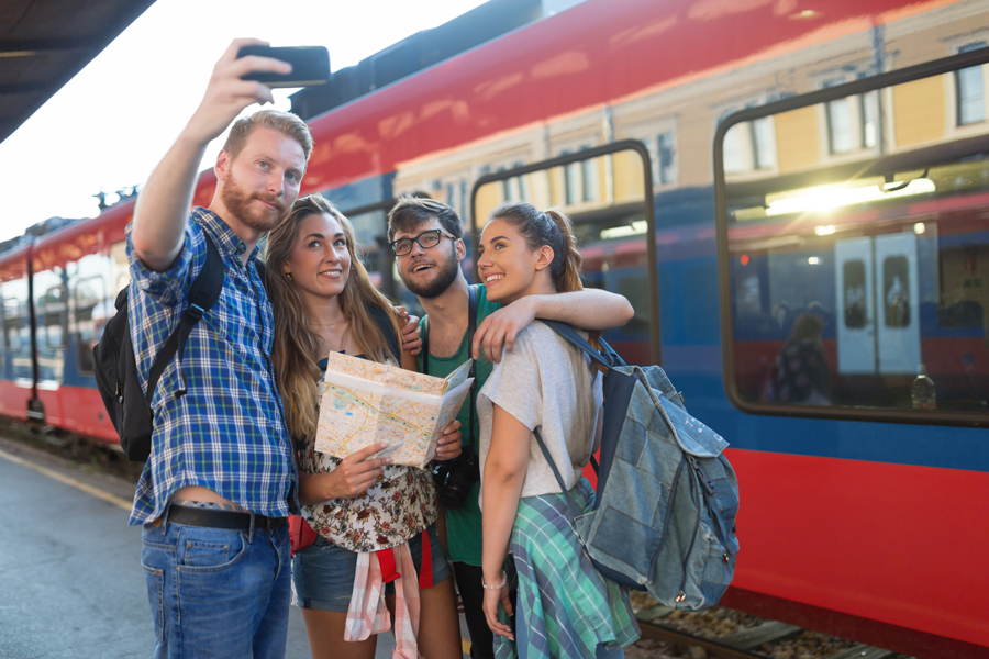 A group of people taking a selfie on a train platform.