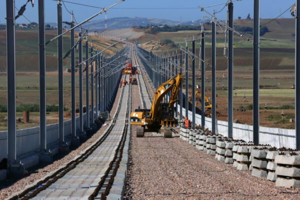 A piece of construction equipment is laying railroad ties down on a new high-speed line.