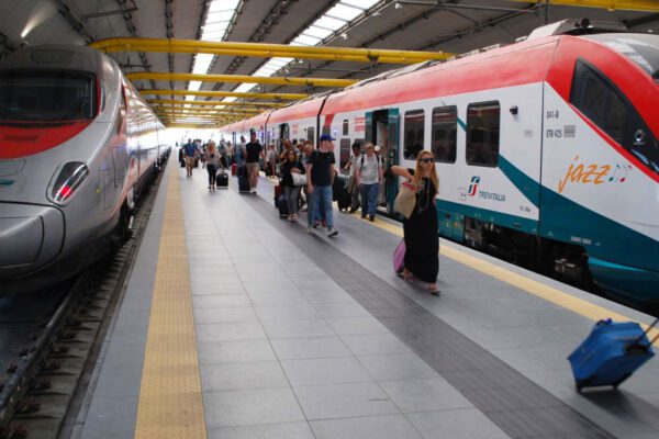 At Rome Airport. People are getting off an airport express train on the right of the platform. A tilting train headed to Florence is on the left side of platform.