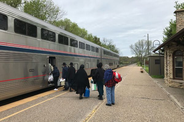 Passengers boarding an Amtrak train at Creston IA, incouding an Amish family.