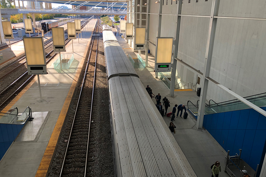 Looking down on a train in the Milwaukee station trainshed with people getting off the train.