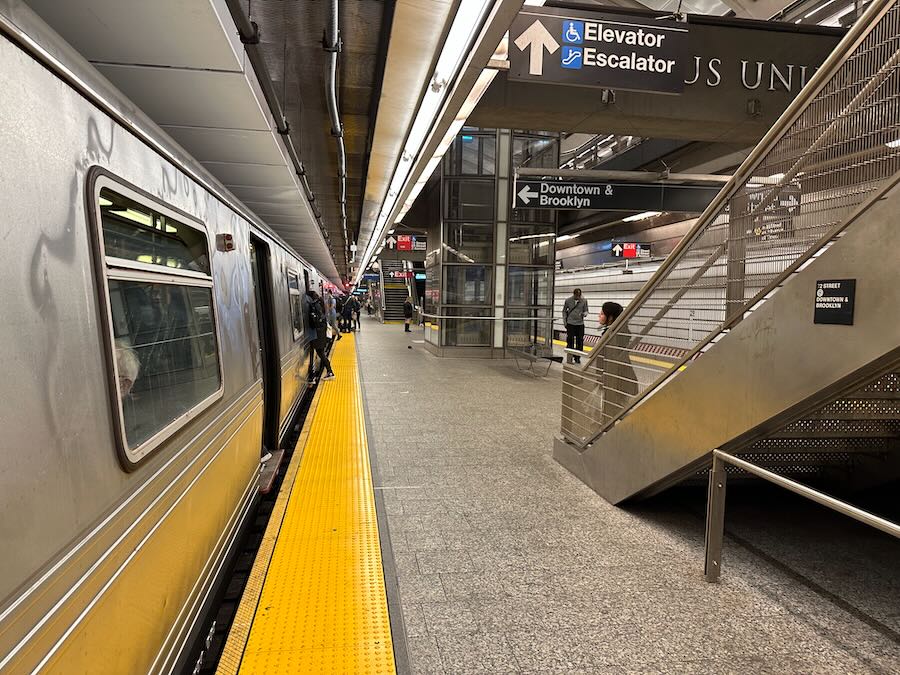 A picture of people baording a Q train on the Second Ave. Subway in NYC.