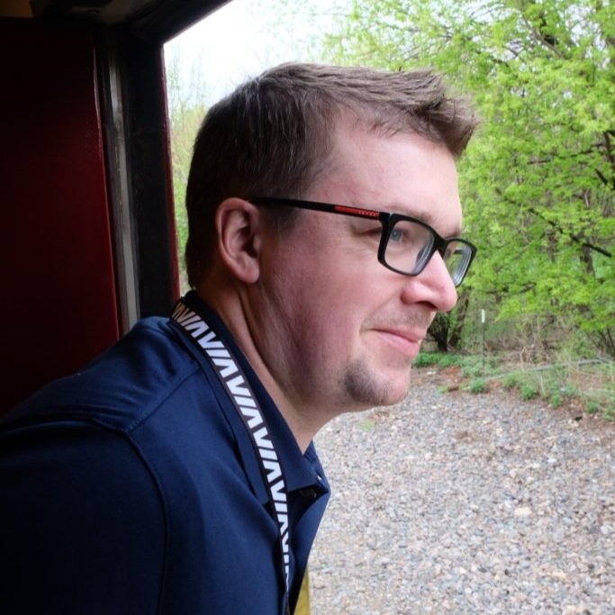 Adam Auxier is looking out the dutch door of an excursion trains.