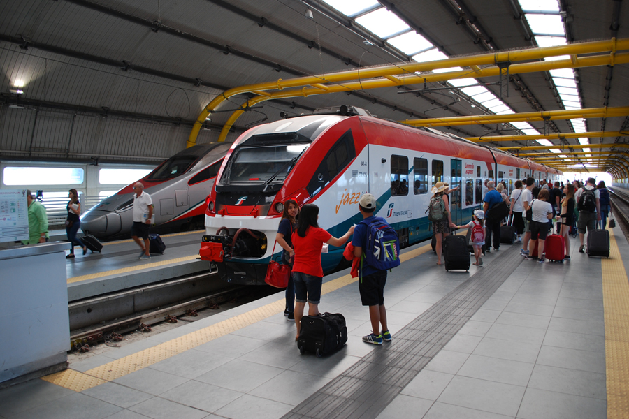 A crowd of passengers who recently arrived by air at Rome's airport are waiting to board a train to the city,