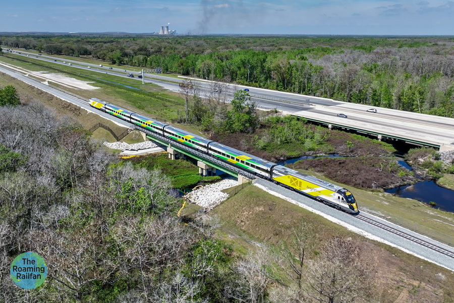 A Brightline train is shown running alongside Florida route 528 from above