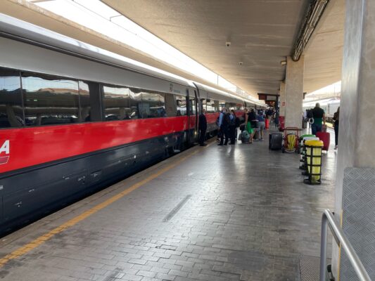 A high-speed train is boarding passengers in Rome.