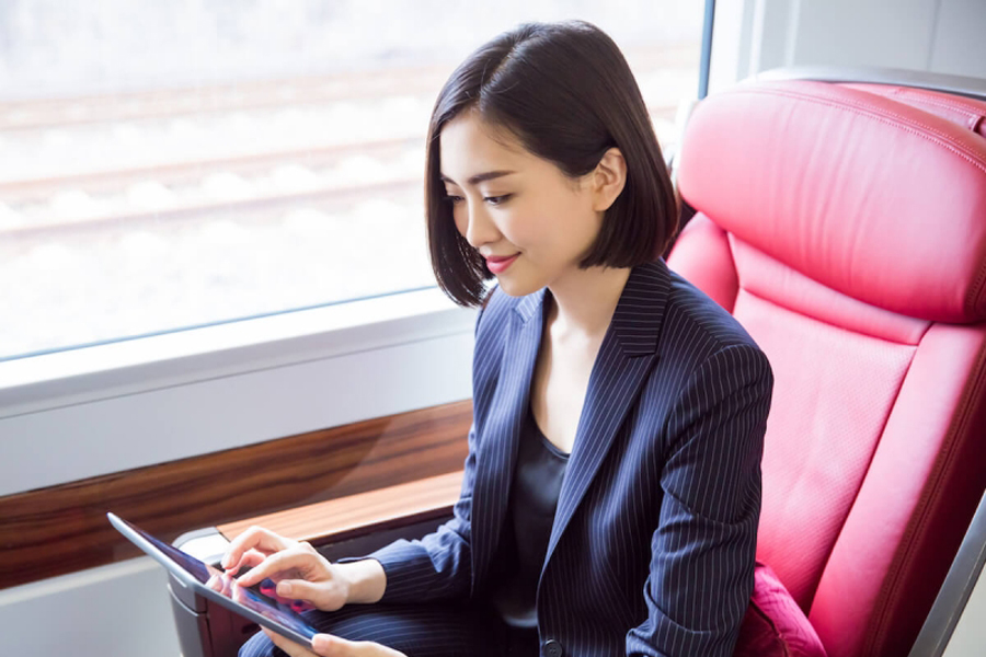 A woman is reading a tablet while riding in first class on a Chinese high-speed train.