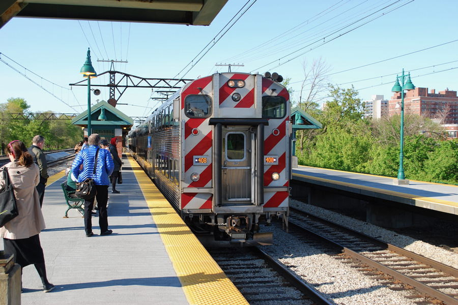 Passengers are waiting on the platform as a soiuthbound Metra electric train arrives.