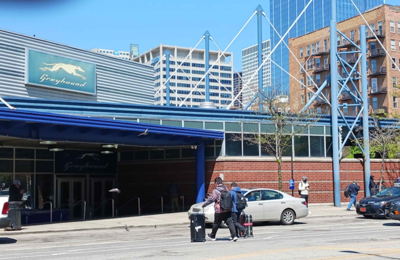 Passengers will roll-aboard luggage are crossing Harrison st. to enter the Chicago Greyhound station.