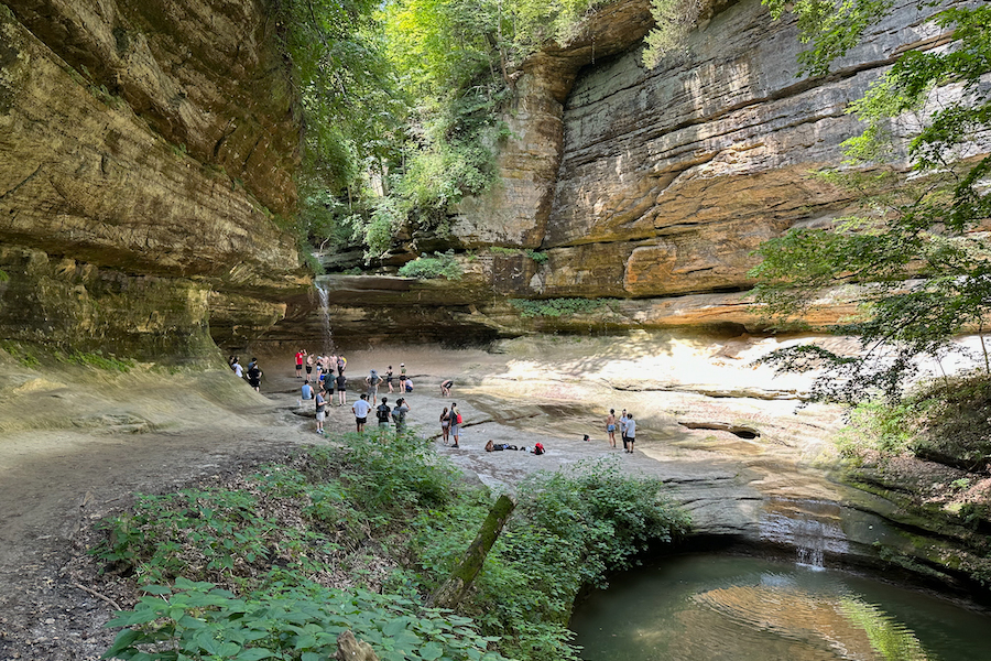 People are looking at a water fall in Starved Rock State Park.