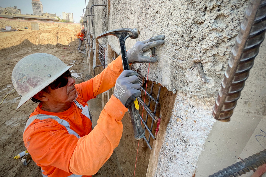 A laborer is working on a concrete wall. 