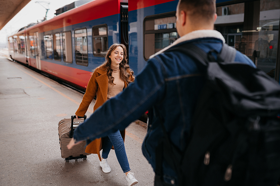 A woman just got off a train is happy to see her friend.