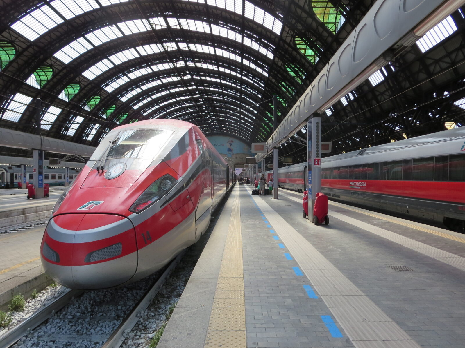 A red Frecciarossa 1000 high-speed train at Milan Central Station, Italy