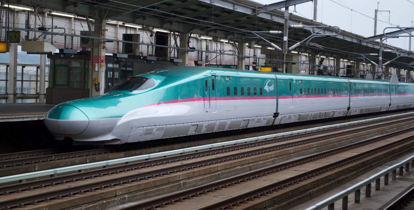 A mint-green JR Hokkaido H5 Shinkansen at a station
